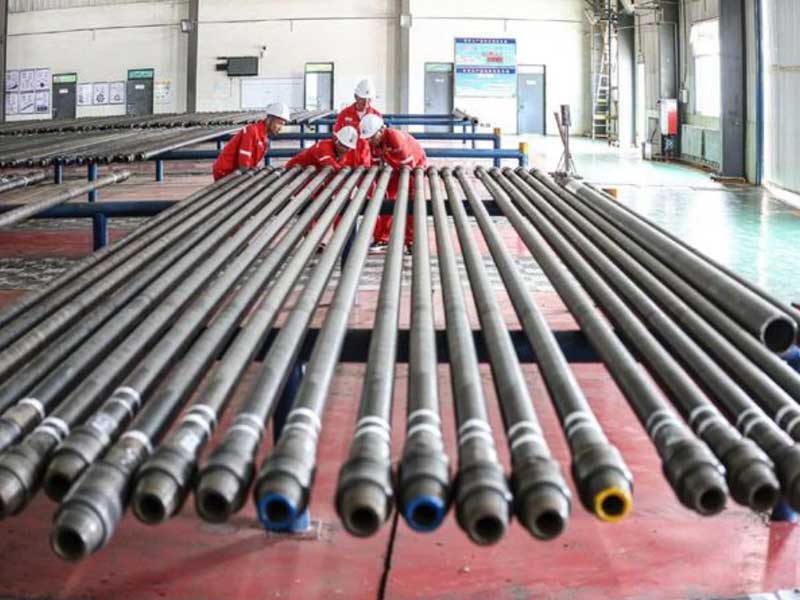 Inspection personnel meticulously examine the quality of the drill pipe, strictly controlling the entry of drilling tools into the well. Photographed by Wang Chengkai.